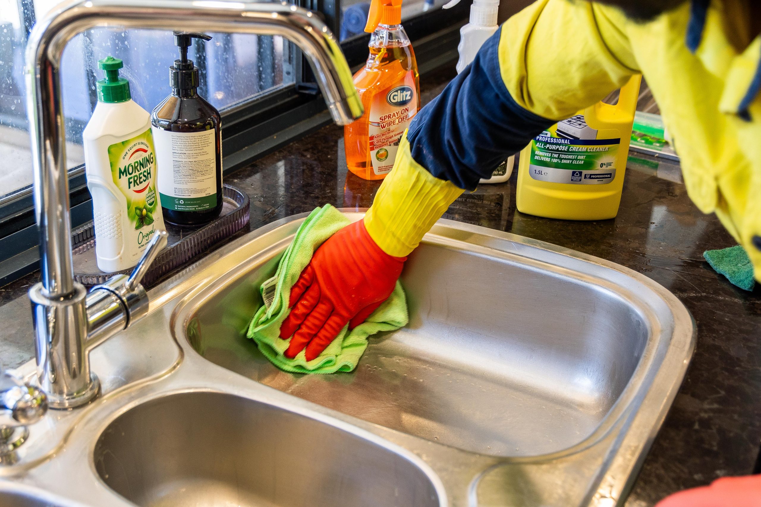 cleaner scrubbing the inside of sink